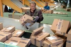 Im Paketausgang im Quelle-Versandzentrum in Leipzig arbeiten zwei Mitarbeiter an Transportbändern. (Archivfoto: dpa)