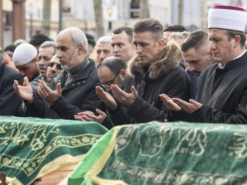 Mit einem muslimischen Totengebet an den Särgen der Opfer nehmen Menschen auf dem Marktplatz von Hanau Abschied. Foto: Boris Roessler/dpa