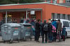 Asylbewerber stehen am Eingang der Zentralen Anlaufstelle (Zast) in Halberstadt
