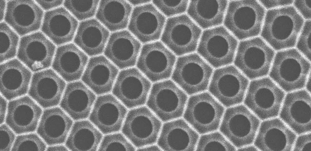 Unter dem Mikroskop ist die Wabenstruktur mit gleichgroßen Poren einer Aluminiumoxid-Nanomembran zu sehen.