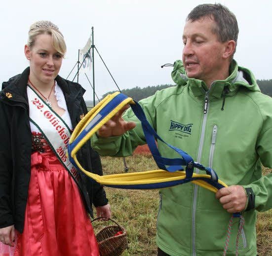Heidekönigin Cindy Huth lässt sich von Rennleiter Thomas Schurig das Hundegeschirr erläutern.