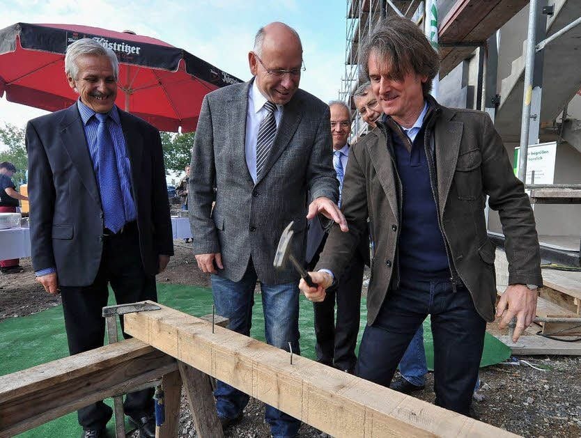 Investor Waldemar Meinecke, Niederlassungsleiter Steffen Kapust und Architekt Karsten Gebhardt (v.l.) schlagen die letzten Nägel ein.