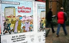 Passanten gehen am Sonntag in Berlin an Werbeplakaten zur Beteiligung am Bürgerentscheid gegen die Umbenennung der Kochstraße zur Rudi-Dutschke-Straße vorbei. (Foto: dpa)