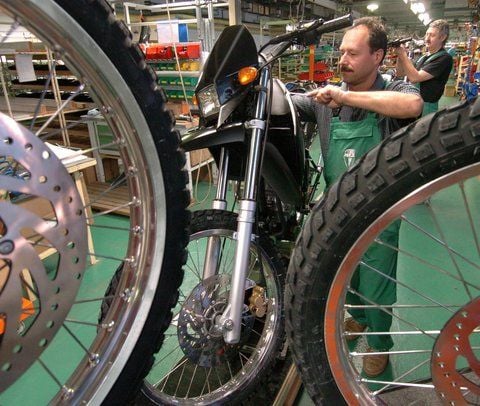 Im Motorradwerk MZ Zschopau arbeitet Uwe Golla (vorn) in der Endfertigung an einer MZ 125 SX Enduros. Nachdem der Betrieb stillgelegt wurde, soll die Produkton jetzt wieder anlaufen. (FOTO: DPA VOM 26.10.2004).