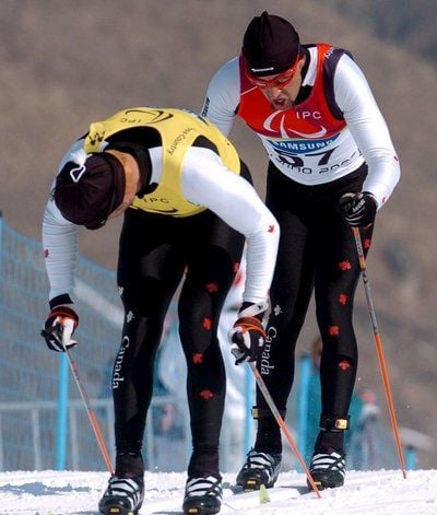 Der Kanadier Brian McKeever (rechts) neben seinem Begeliter auf dem Weg zum Sieg beim Langlaufwettbewerb der Blinden bei den Paralympics Turin 2006. (FOTO: DPA)