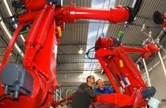 Im neuen Autozulieferwerk von Magneto Automotive Deutschland (MAD) in Treuen informieren sich am Freitag (25.04.2003) der Anlagenführer Kai Selbmann (l) und der Elektriker Hans-Peter Pöschel über die Arbeitsweise der ersten Industrieroboter für die Montagelinien. (Foto: dpa)