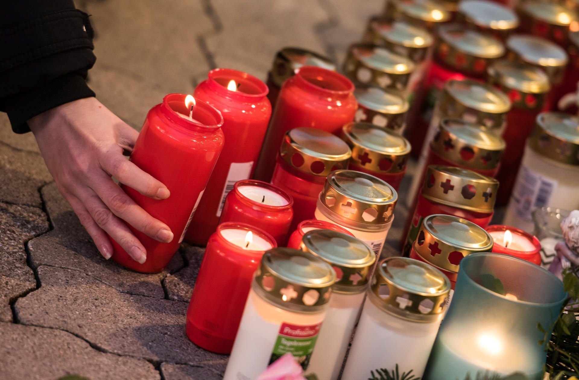 Ein junge Frau stellt am 28.12.2017 vor dem Drogeriemarkt in Kandel (Rheinland-Pfalz) eine Kerze ab.