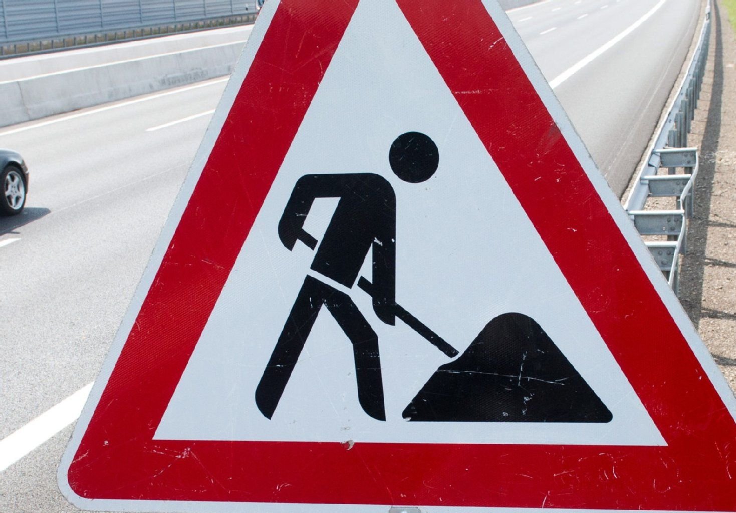 Ein Schild weist an der Autobahn auf eine Baustelle hin.