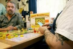 Gefangene der JVA-Moers-Kapellen spielen unter der Aufsicht von zwei Vollzugsbeamten in einem Haftraum das von ihnen erarbeitete Brettspiel «Ohne Bewährung». (Foto: dpa)