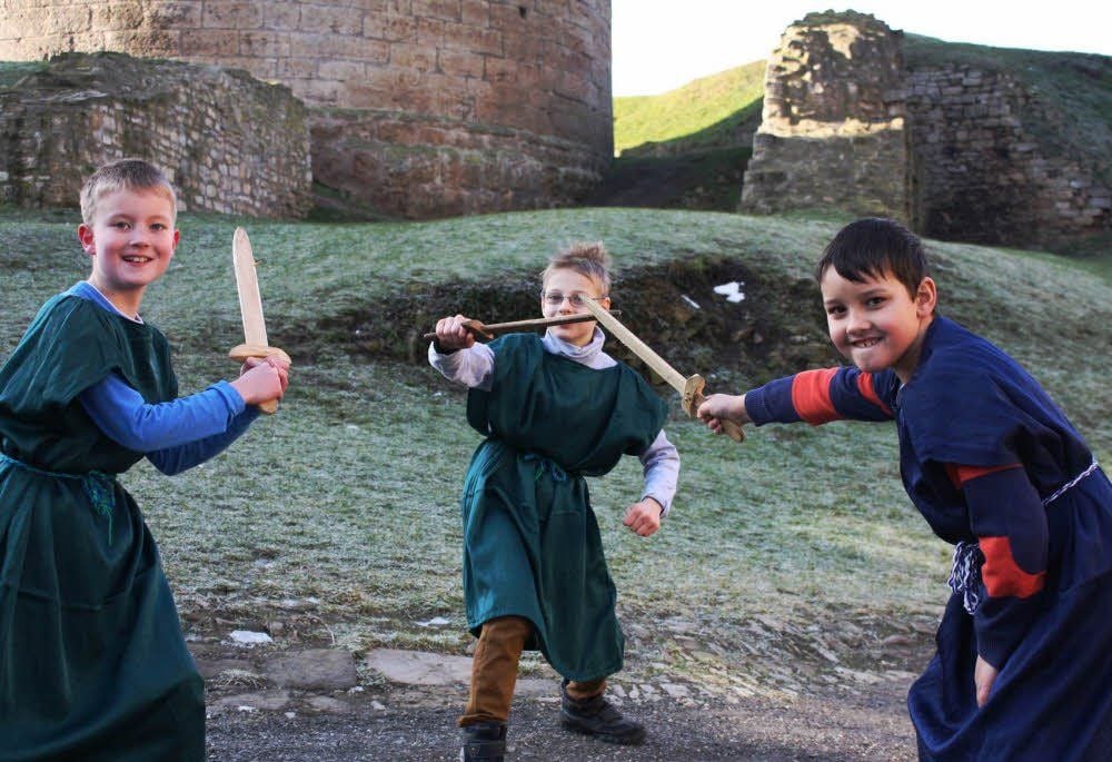 Paul Göbel, Christian Junker und Lukas Kressner (von links) üben sich im Schwertkampf vor dem „Dicken Heinrich“ auf Burg Querfurt.