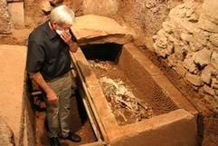 Winfried Weber, Direktor des Bischöflichen Dom- und Diözesanmuseums betrachtet unterhalb der Abteikirche St. Matthias in Trier den Inhalt eines soeben geöffneten Steinsarges aus römischer Zeit. (Foto: dpa)