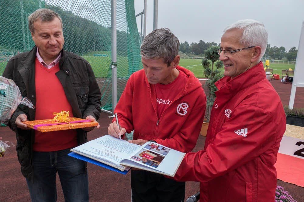 Der WM-Dritte im Marathon, Mike Poch, trug sich unter den Augen von Wolfgang Scheller (l.) und Konrad Sutor in das Goldene Buch ein.