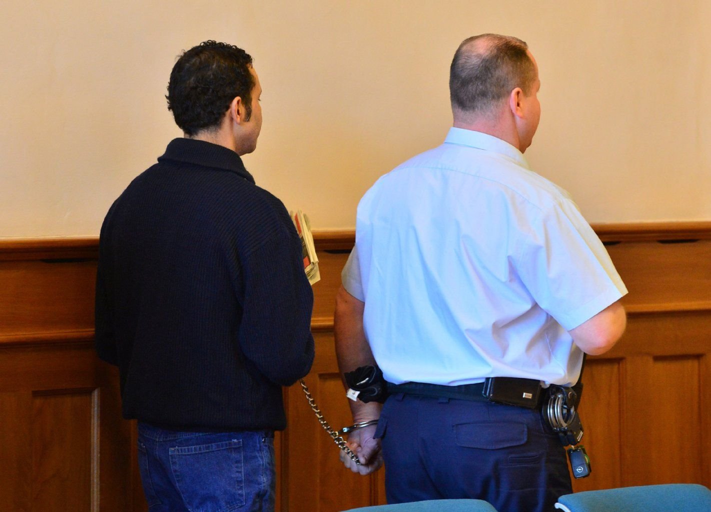 Der Angeklagte Temime M. (li.) wird von einem Justizbediensteten in den Verhandlungssaal im Landgericht in Erfurt geführt.