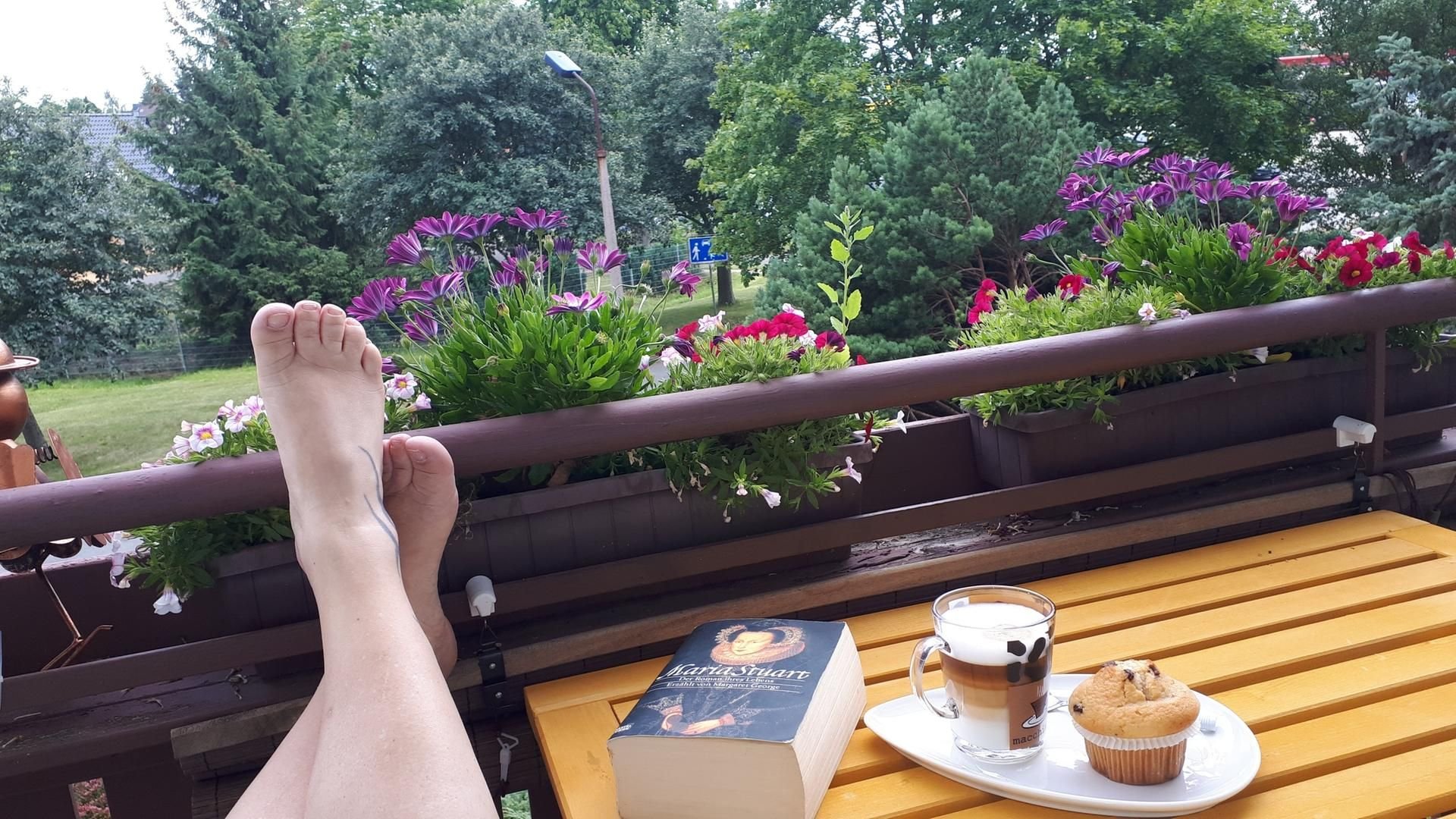 Heike Teichmann aus Harzgerode entspannt mit einem Buch und einem Muffin auf ihrem Balkon daheim.