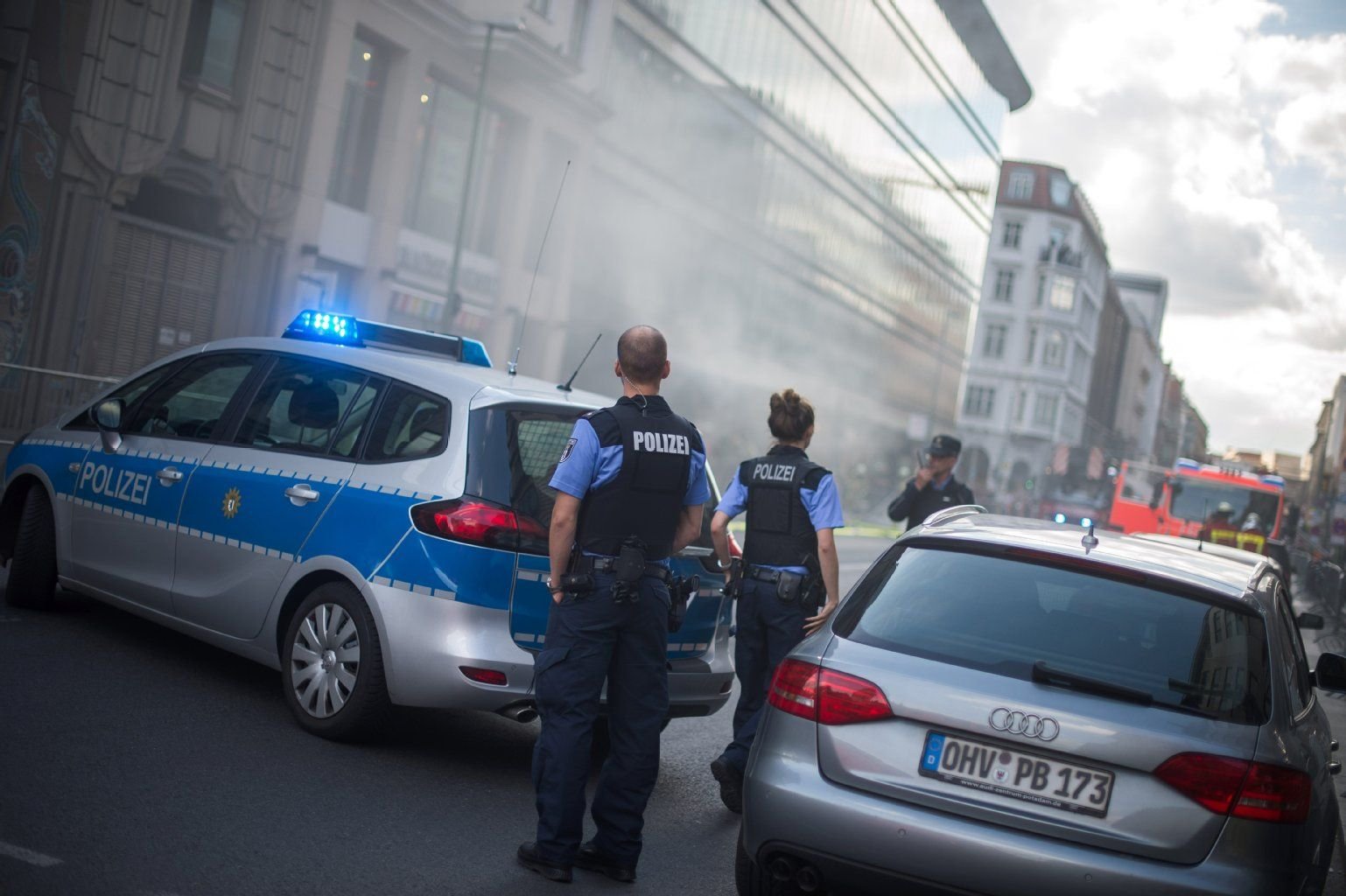 Einsatzkräfte der Polizei sichern die Straße vor dem Kaufhaus Galeries Lafayette, aus dem starker Rauch dringt.
