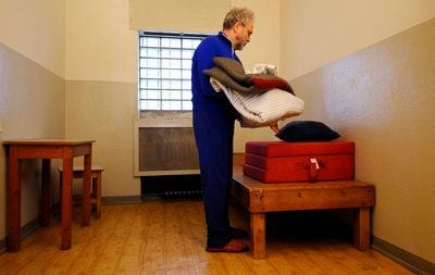 Der ehemalige Stasi-Häftling Carl-Wolfgang Holzapfel legt in Berlin in seiner damaligen Zelle 207 der ehemaligen Stasi-Untersuchungshaftanstalt Berlin-Hohenschoenhausen sein Bettzeug ab. (FOTO: DDP)