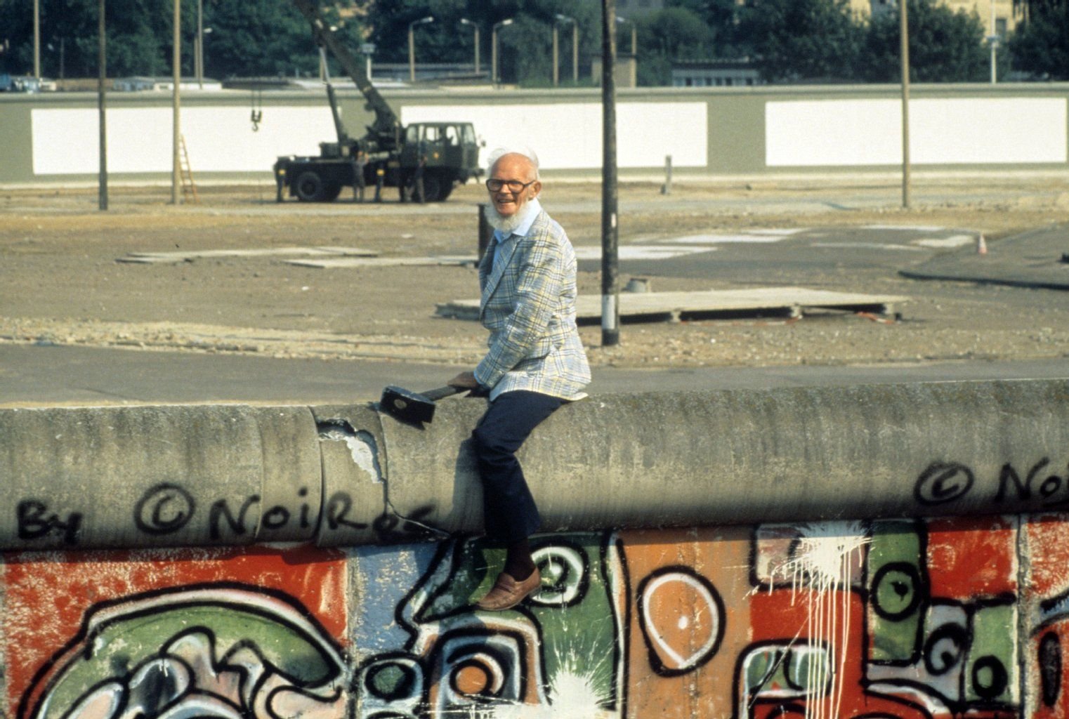John Runnings demonstriert am 07.08.1986 mit einem Balanceakt gegen den Bau der Berliner Mauer am 13. August 1961. Mit einem großen Vorschlaghammer führt der 69-jährige Amerikaner vor, was seiner Meinung nach mit dem Bauwerk zu tun sei.