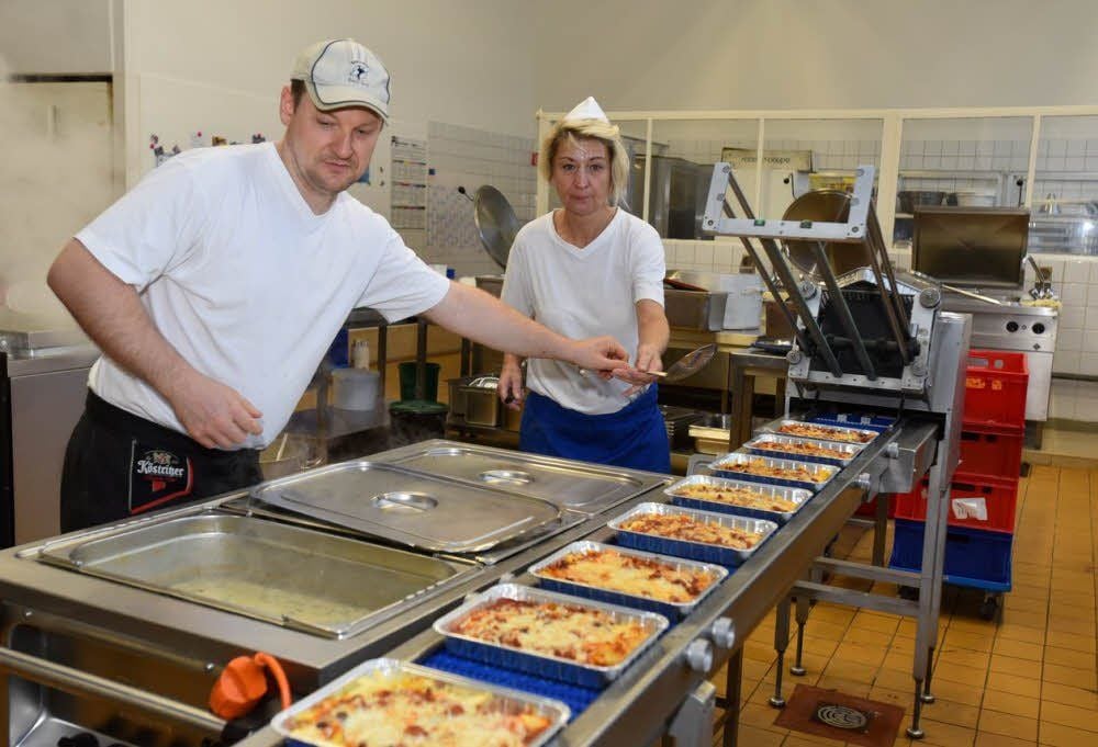 Bereiten bei Menü-Service Essen zur Auslieferung an Schulen vor: Enrico Ehring und Marion Reinhardt.