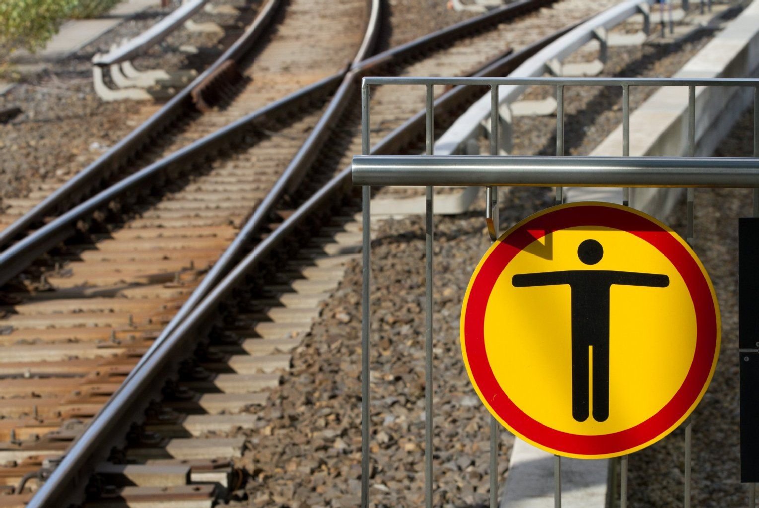 Warnschild an einer Bahnstrecke.