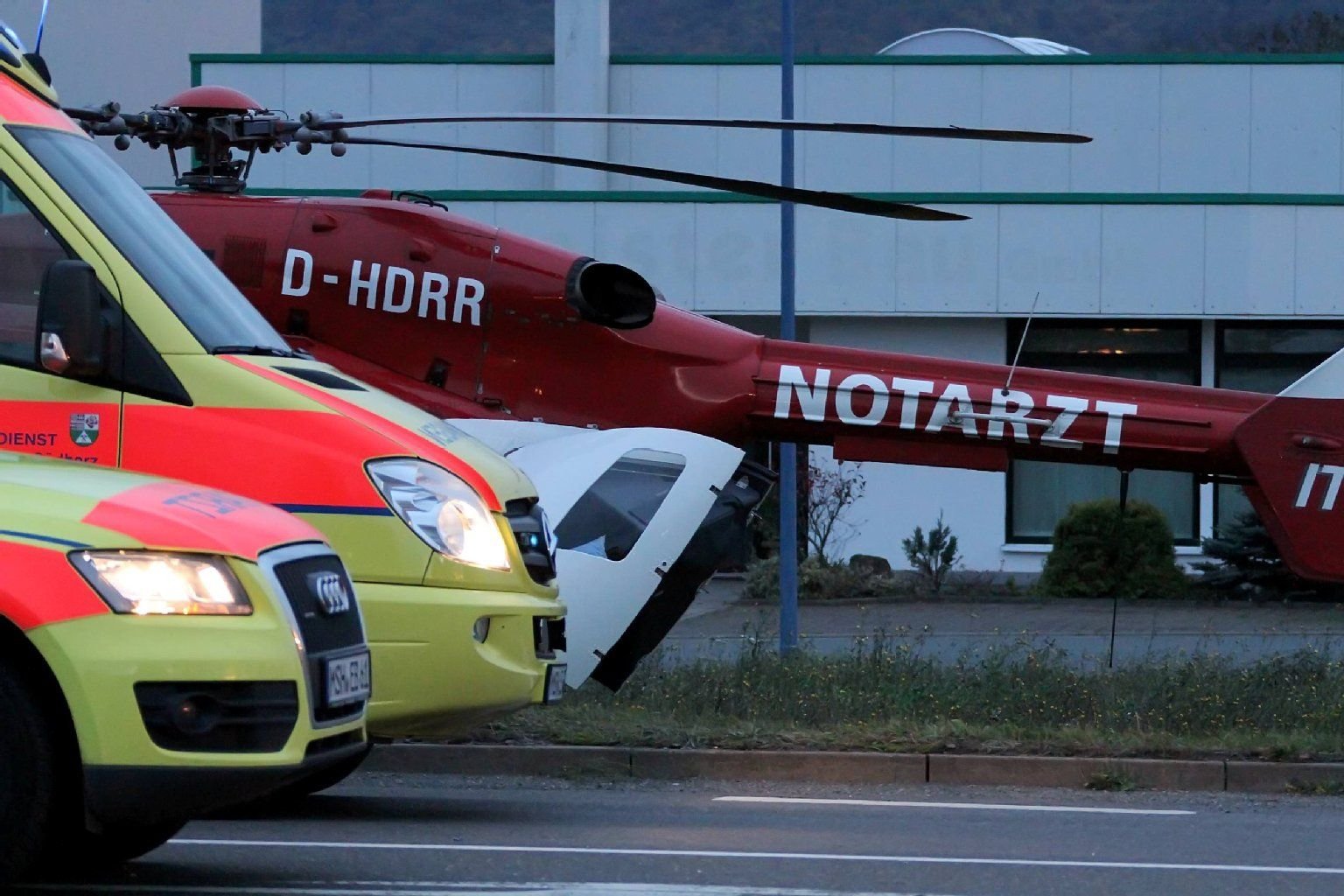 Ein Notarztwagen steht neben einem Rettungshubschrauber.
