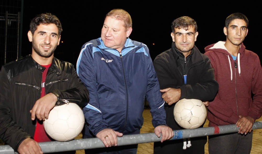 Der Vorstandsvorsitzende des FC Hettstedt, Bernd Kühne (2.v.l), mit den syrischen Flüchtlingen Murad Bengin (2.v.r) und den beiden Spielern Mesud (l.) und Hussein (r.). Bengin trainiert auch das Integrationsteam.