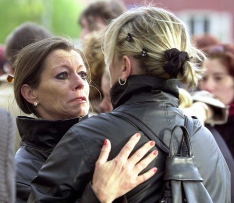 Mit Tränen in den Augen schaut die damalige Schulleiterin des Erfurter Gutenberg-Gymnasiums, Christiane Alt (l.), am 29. April 2002 vor der Schule in Erfurt in das Gesicht einer Lehrerkollegin. (ARCHIVFOTO: DPA)