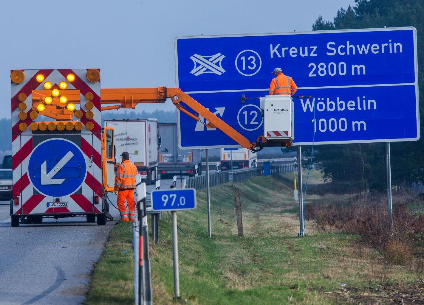 Mitarbeiter der Autobahnmeisterei reinigen in der Nähe von Wöbbelin (Mecklenburg-Vorpommern) einen Wegweiser vor dem neuen Autobahnkreuz Schwerin.
