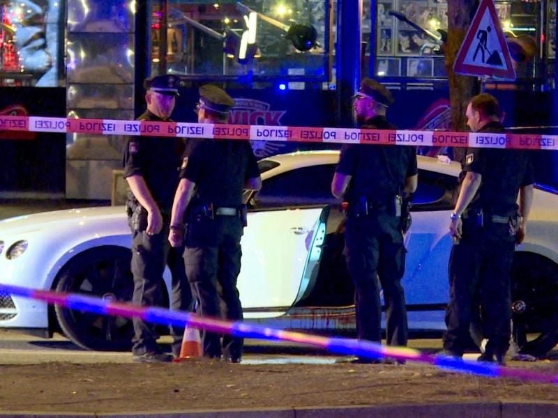 Polizisten stehen neben dem Auto des Rockerbosses auf dem Millerntorplatz an der Reeperbahn, nachdem die Schüsse gefallen waren. Foto: Mücahid Güler/dpa