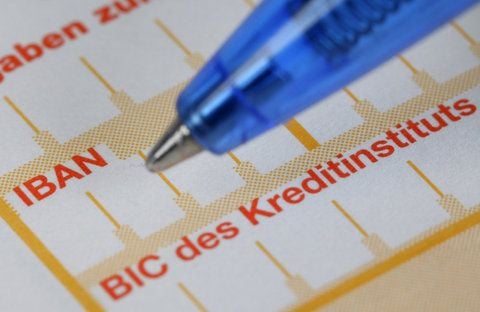 Ein Kugelschreiber ist neben einem Überweisungsträger mit den Schriftzügen «IBAN» und «BIC» zu sehen.