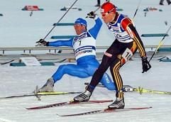 Tobias Angerer (vorne) aus Deutschland schiebt seinen Ski am Mittwoch (26.02.2003) im italienischen Tesero im Val di Fiemme (Fleimstal) im Viertelfinale des Sprintrennens bei den nordischen Ski-Weltmeisterschaften als Zweiter vor dem Schweden Anders Hoegberg (hinten) über die Ziellinie. Der Schwede Thobias Fredriksson (nicht im Bild) gewann den Viertelfinal-Lauf und wurde am Ende Weltmeister. Angerer belegte im Finale den vierten Platz. (Foto: dpa)