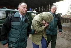 Zwei Polizeibeamte führen in Großbottwar einen wegen Mordes angeklagten Mann bei einem Ortstermin auf den Reiterhof, wo er 1984 ein zwöfjähriges Mädchen sexuell mißbraucht und anschließend erdrosselt hat (Foto vom 11.01.2005). (Foto: dpa)