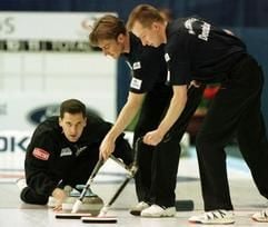 Der Skip der deutschen Curling-Mannschaft (l) sowie zwei „Wischer“ in Aktion (Foto: dpa, Archiv).