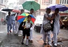 Wasser überall: Indische Schulkinder sind in Jammu im Kaschmir unterwegs. (Foto: dpa)