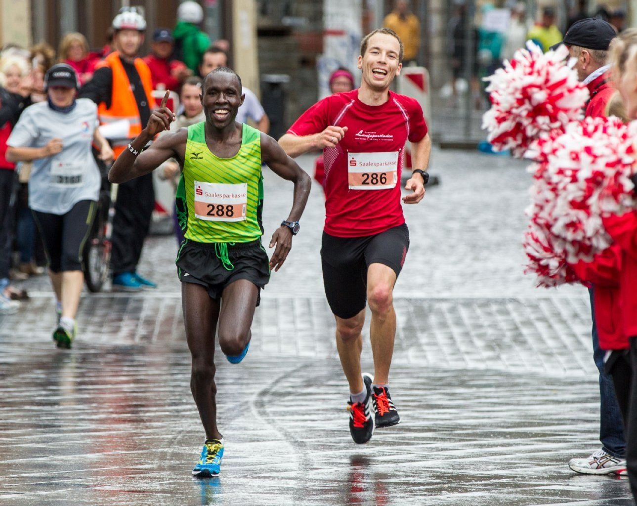 Als Sieger des 14. Mitteldeutschen Marathon kommt der Kenianer Dickson Kurui (l.) mit Vorjahressieger Andre Fischer (r.) ins Ziel auf dem Markt in Halle an.