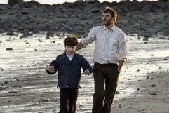 Erthan Learner (Joaquin Phoenix) und sein Sohn spazieren am Strand in einer Szene des Films «Ein einziger Augenblick». Auf der Heimfahrt überfährt Dwight Arno den zehnjährigen Jungen, der wenig später stirbt. (Foto: dpa)