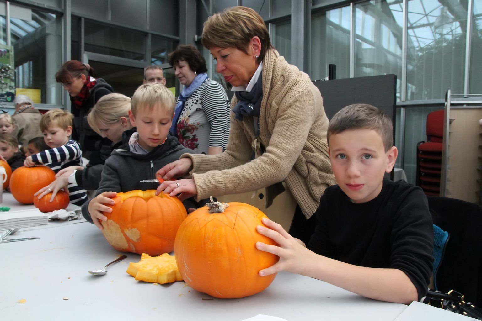 Hannes, Oma Monika Brodmann und Moritz beim Kürbisschnitzen im Glashaus des Rosariums.