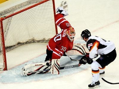 Eishockey Länderspiel - Chris Mason (l) aus Kanada und der Deutsche Daniel Kreuzer (r) kämpfen um den Puck. (FOTO: DPA)