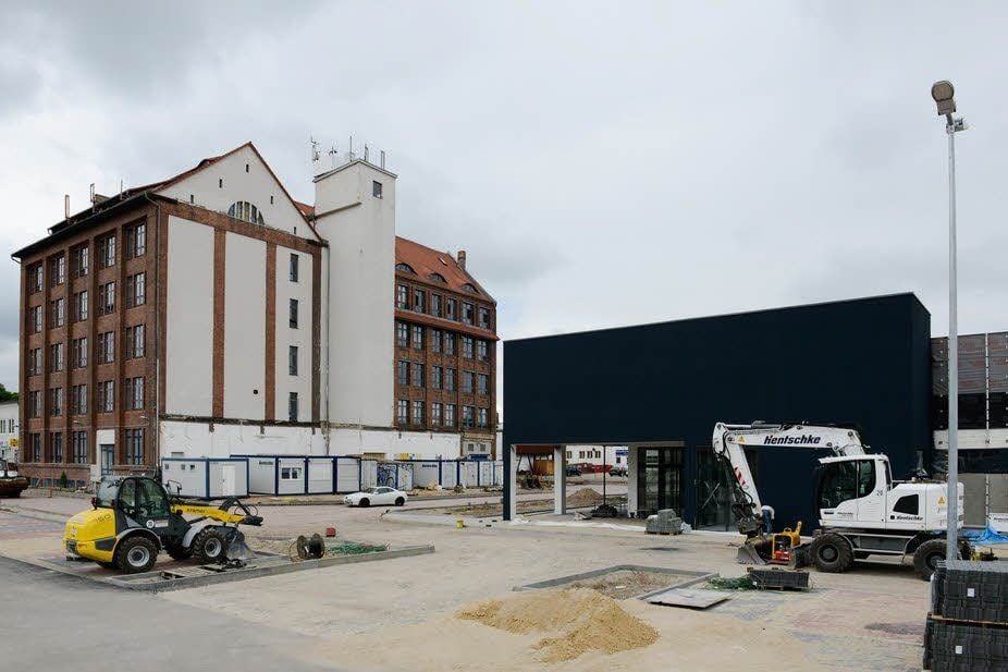 Hinter dem sanierten Gebäude der Hermes-Fabrik wird ein neuen Einkaufszentrum gebaut.