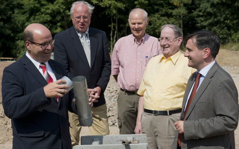 Mit Bürgermeister Thomas Balcerowski (r.) füllt Bauherr Jörg Biastoch (l.) die Kassette mit Zeitdokumenten für den Grundstein.