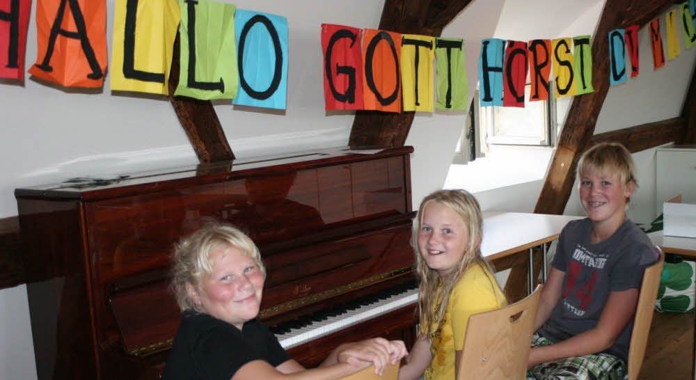Über den musizierenden Kindern hängt das Motto der Ferientage: „Hallo Gott, hörst du mich?“