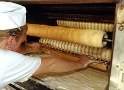 Eine Bäckerin arbeitet in der Harzer Baumkuchen Friedrich GbR in Wernigerode am Ofen. Mit einem so genannten Kamm wird die thypische Form des Friedrich'schen Kuchens erzeugt. (Foto: dpa)