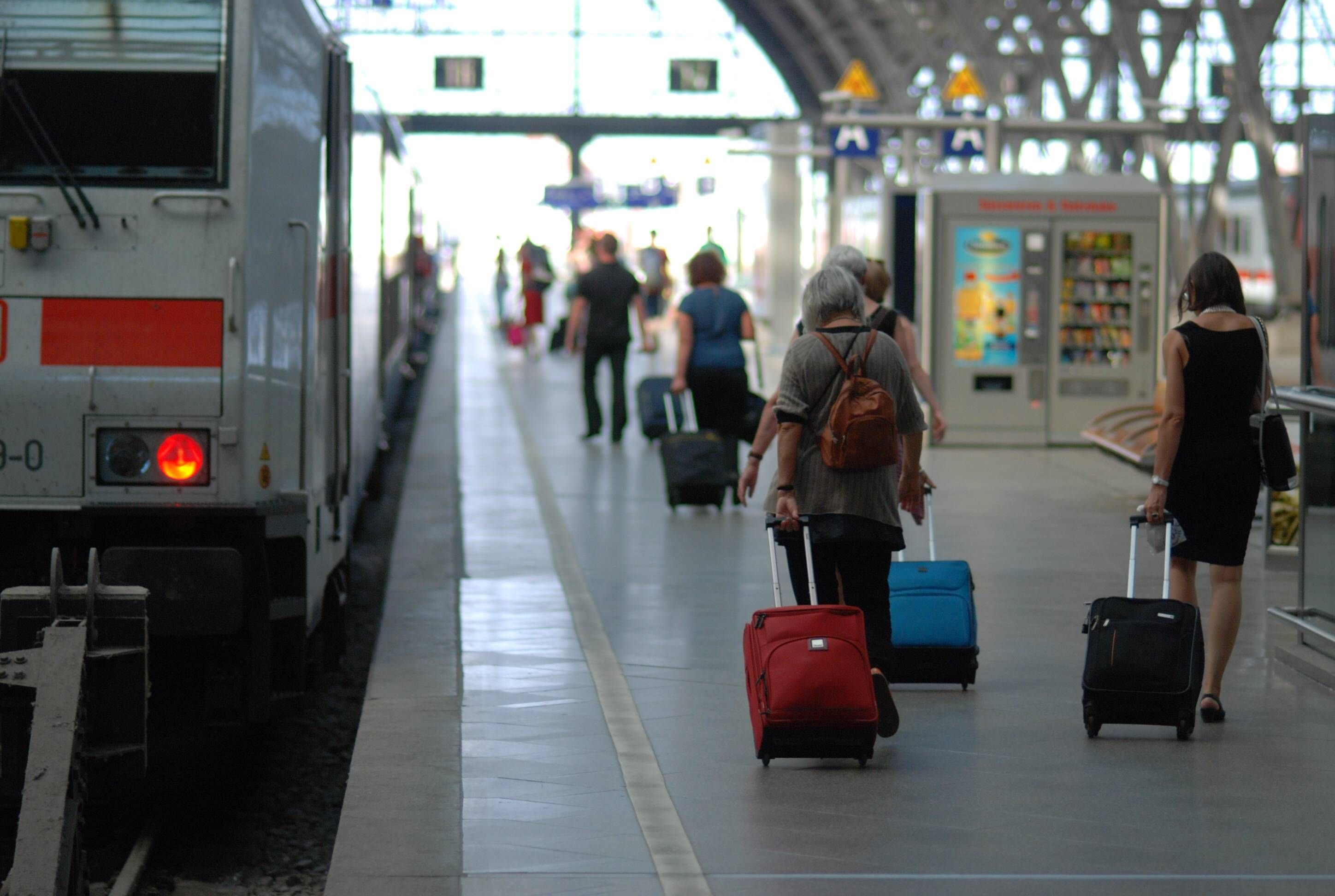 Bahnreisende gehen zu einem Zug am Leipziger Hauptbahnhof.