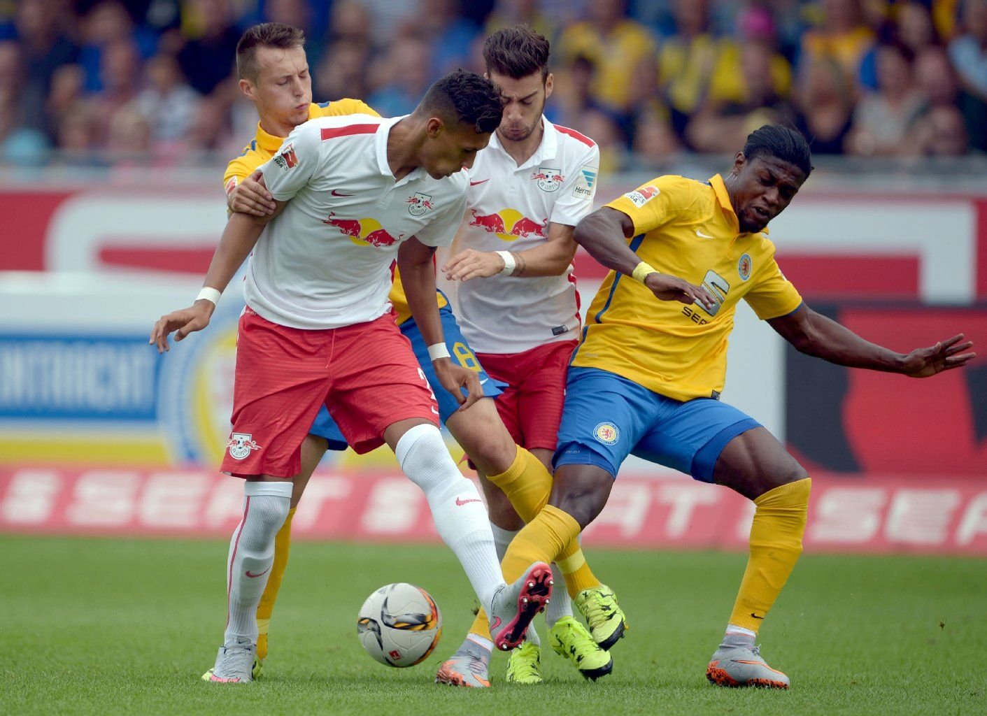 Braunschweigs Adam Matuschyk (l) und Joseph Baffo (r) im Kampf um den Ball mit Leipzigs Davie Selke (2.v.l) und Massimo Bruno.