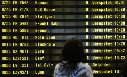 Eine Frau steht auf dem Flughafen Berlin-Schönefeld vor einer Anzeigetafel. (ARCHIVFOTO: DPA)