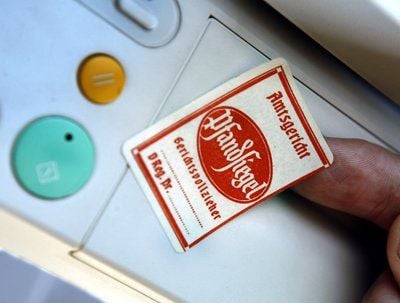 Ein Gerichtsvollzieher klebt ein Pfandsiegel («Kuckuck») auf einen zu pfändenden Kopierer. (FOTO: DPA)