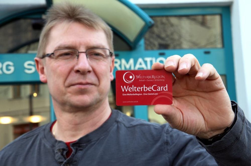 Heiko Triepel, Mitarbeiter der Bernburger Stadtinformation, zeigt die Welterbecard.