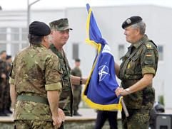 Der amerikanische General Henry G. Ulrich (M.) vom Nato-Kommando in Neapel übergibt in Pristina im Kosovo die Nato-Flagge vom Italiener Giuseppe Valotto (l.) an den deutschen General Roland Kather. (Foto: dpa)