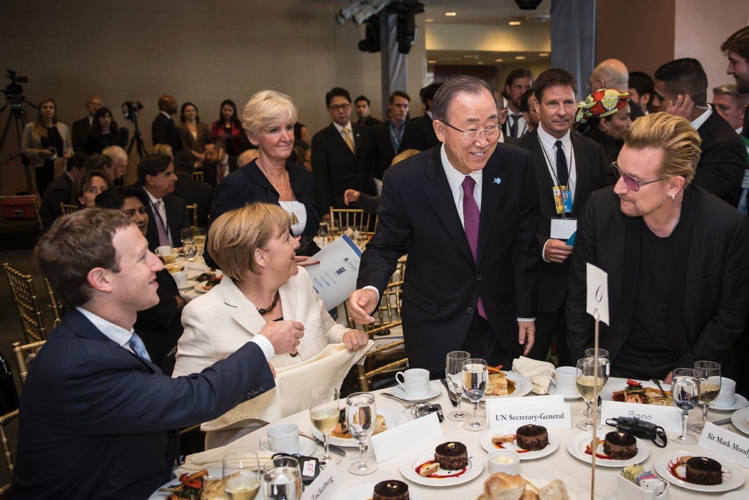 Angela Merkel sitzt neben Mark Zuckerberg, während UN-Generalsekretär Ban Ki-Moon (2.v.r) und der Sänger Bono (r) an den Tisch kommen.