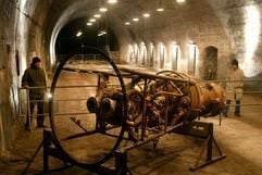 Reste eines Antriebsblocks mit Brennkammer einer V2-Rakete besichtigen zwei Besucher in einem unterirdischen Stollen der KZ-Gedenkstätte Mittelbau-Dora in Nordhausen. (Foto: dpa)