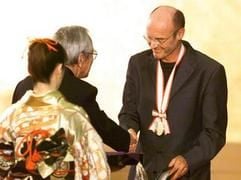 Der deutsche Maler Anselm Kiefer nimmt in Tokio seinen Kunstpreis Praemium Imperiale aus den Händen eines Vorstand der Japan Art Association entgegen (Archivfoto vom 28.10.1999). Seine Werke brechen lieb gewordene Tabus, loten große Mythen der Menschheit aus und suchen in einer als absurd empfundenen Welt nach Bausteinen der Erinnerung. Kiefer, der in Deutschland so umstritten ist wie anderswo anerkannt, lebt in Nimes am Fuße der südfranzösischen Cevennen. Dort baut der Künstler, der am kommenden Dienstag (8. März) 60 Jahre alt wird, auf seinem 35 Hektar großen Ateliergelände seit mehr als einem Jahrzehnt an einem riesigen Gesamtkunstwerk aus Installationen, unterirdischen Kammern, Glasbauten und Hangars. (Foto: dpa)